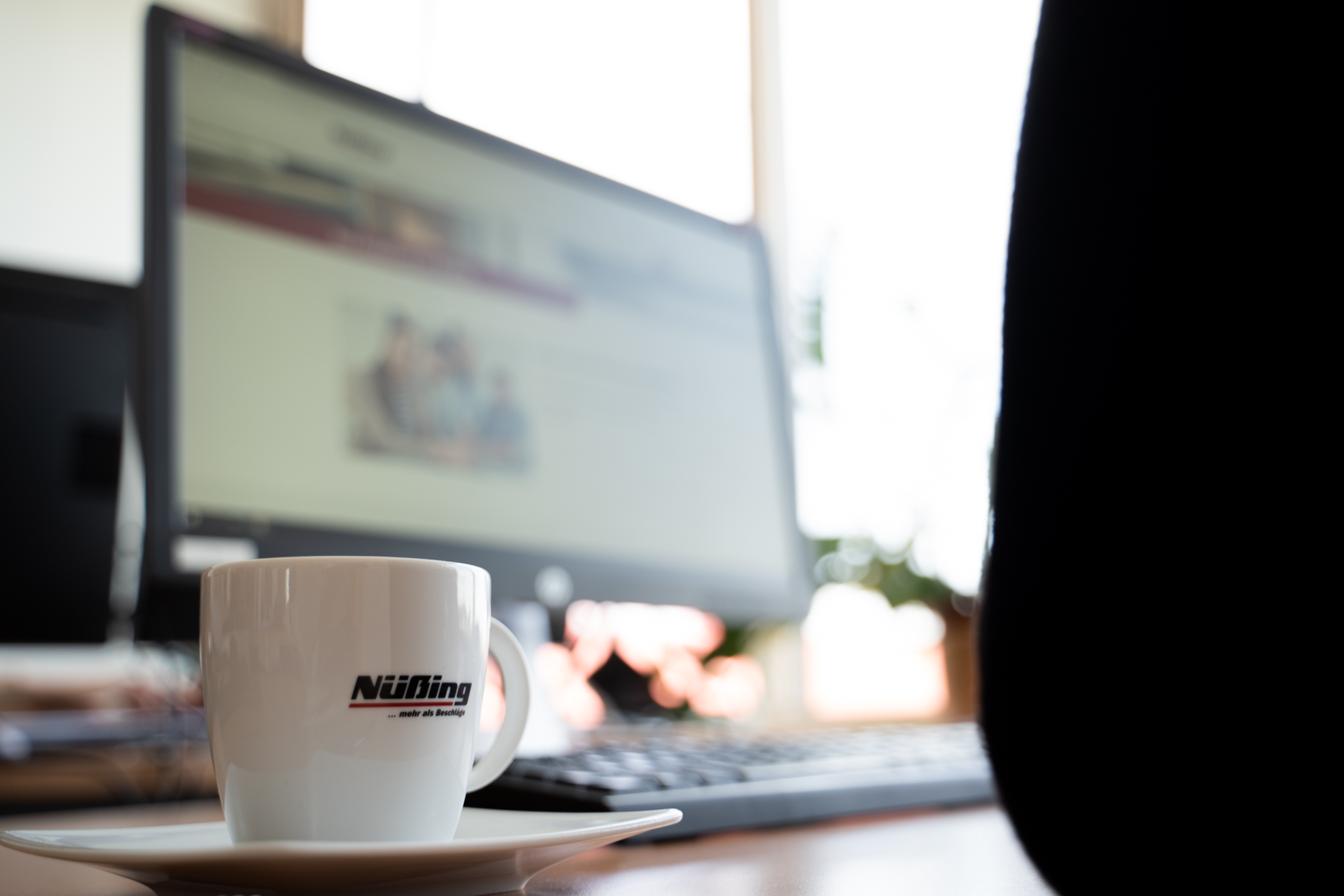 Schreibtisch mit Monitor und Kaffeetasse